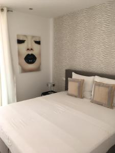 a bedroom with a bed with a picture of a woman at Prassa 3 Boutique Hotel in Mindelo