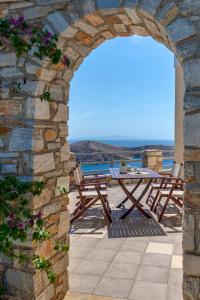 an archway with a table and chairs on a patio at Villa la vue in Ano Syros