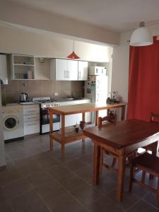 a kitchen with a wooden table and a wooden table sidx sidx sidx at Departamento temporario Puerto Madryn in Puerto Madryn