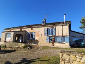 a large stone house with a driveway in front of it at Maison d'HÔTES LA FEZENDES in Miradoux