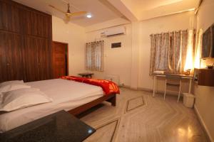 a bedroom with a bed and a desk and a window at Venkys Service Apartment in Secunderabad