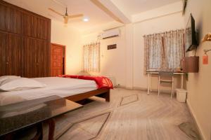 a bedroom with a bed and a desk in it at Venkys Service Apartment in Secunderabad