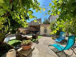 a patio with chairs and a table and a house at Maison climatisée 5 pièces avec jardin privé et parking, proche gare et centre à Argelès-sur-Mer - FR-1-388-217 in Argelès-sur-Mer