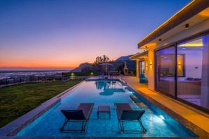 Villa Saudade في Bulmaç: مسبح في بيت مع غروب الشمس