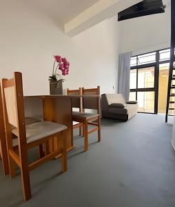 - un salon avec une table, des chaises et un canapé dans l'établissement Lofts Meia Morada SFS, à São Francisco do Sul