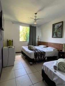 a hotel room with two beds and a window at Pousada Cantim de BH in Venda Nova