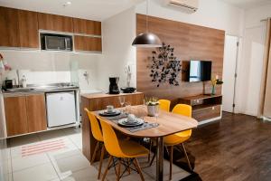 uma cozinha e sala de jantar com mesa e cadeiras amarelas em Mondial Apartments By BnbHost em Salvador