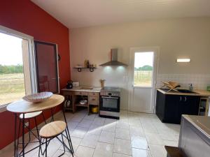 eine Küche mit roten Wänden sowie einem Tisch und Stühlen in der Unterkunft Gîte Le Lude, 3 pièces, 4 personnes - FR-1-410-413 in Le Lude