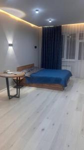 een slaapkamer met een bed en een tafel in een kamer bij Good Home на 8 персон in Alma-Ata