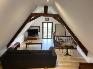 a living room with a couch and a table at Gîte de charme au bord de l'eau, à 30min du Mans, cadre paisible avec pêche et randonnées à proximité - FR-1-410-414 in Congé-sur-Orne