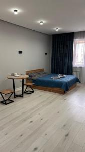een slaapkamer met een bed en een tafel. bij Good Home на 8 персон in Alma-Ata