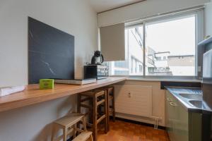 eine Küche mit einer Theke mit einem Waschbecken und einem Fenster in der Unterkunft MUL HOUSE in Mulhouse