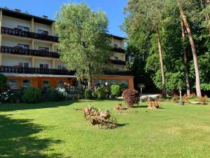 a building with a yard with animals in the grass at Parkhotel Zuzek in Sankt Kanzian