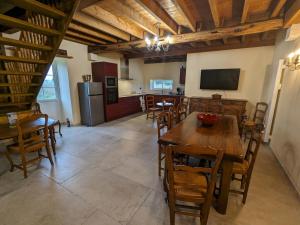 a kitchen and dining room with wooden tables and chairs at Gîte chaleureux avec jardin, accueil chevaux, proche Loire à Vélo et sites historiques - FR-1-590-415 in Sigloy