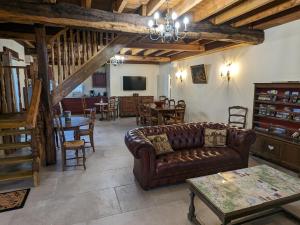 a living room with a couch and a table at Gîte chaleureux avec jardin, accueil chevaux, proche Loire à Vélo et sites historiques - FR-1-590-415 in Sigloy