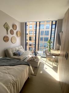 a bedroom with a bed and a couch and a desk at Chic downtown loft - near Zona Rosa in Bogotá
