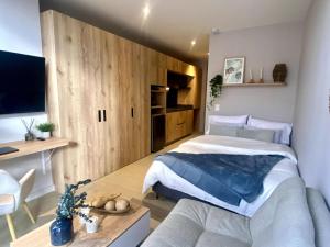 a bedroom with a large bed and a couch at Chic downtown loft - near Zona Rosa in Bogotá