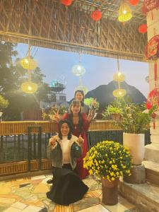 drie vrouwen poseren voor een foto voor een gebouw bij Hang Mua Bungalow in Ninh Binh