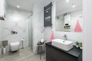 un bagno bianco con lavandino e WC di Kairos Apartments - Solar - klimatyzacja, ścisłe centrum, Spodek a Katowice Altre 25 foto