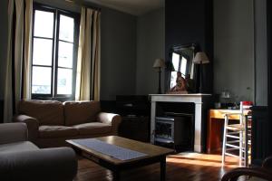 salon z kanapą i kominkiem w obiekcie La Terrasse d'Octave w mieście Saint-Aignan