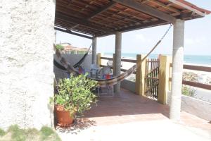 Casa c WiFi a beira mar na Praia Redonda,Icapui CE في إيكابوي: شرفة مع أرجوحة والشاطئ
