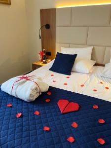 Hotel Wellness & Spa Nowy Dwór في جيشوف: سرير بقلوب عليه بطانيه زرقاء