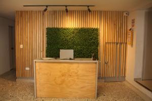Una pared verde detrás de un escritorio con un ordenador portátil. en Hotel la Carpita, en El Poblado