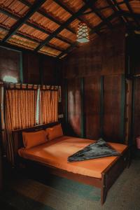 a bedroom with a bed in a wooden room at LEXI MEADOWS in Virajpet