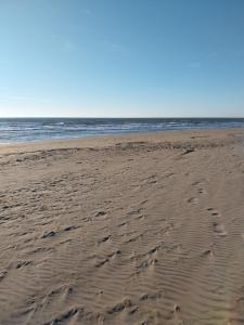 a beach with footprints in the sand and the ocean at La Torre di Barbara in Ardea