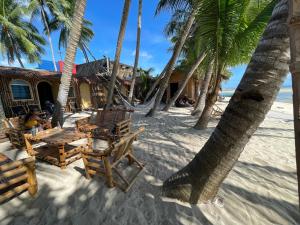 a beach with chairs and palm trees on the sand at Voodoo House in Lalao