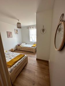 - 2 lits dans une chambre avec un miroir dans l'établissement Maison neuve proche plage et forêt, à Saint-Jean-de-Monts
