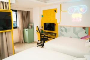 a room with two beds and a desk and a tv at Hotel Magic Games 4 in Oropesa del Mar