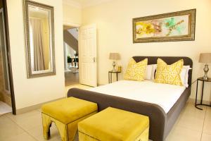 una camera con un letto e due sgabelli gialli di Villa 37 on Westridge a Durban