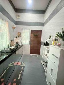 a kitchen with a glass counter and a refrigerator at Homestay taiping in Taiping