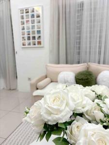 a bouquet of white roses in a living room at Homestay taiping in Taiping
