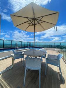 a patio table with an umbrella on a roof at Flat Premium Recife-Ilha do leite in Recife