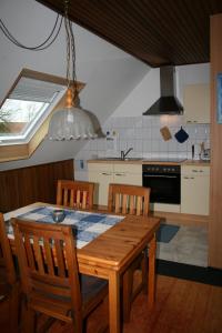ヴァンガーラントにあるFeWo Zur entspannten Weitsichtのキッチン(木製テーブル、椅子、窓付)