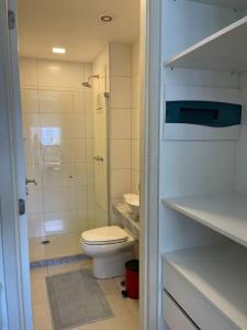 a white bathroom with a toilet and a shower at Flat Premium Recife-Ilha do leite in Recife