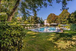 a swimming pool in a yard with umbrellas at Borgo Cà dei Sospiri in Quarto dʼAltino