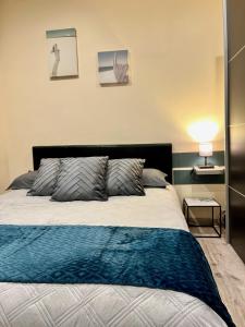 a bedroom with a bed with a blue blanket at La Villa l'Oiseau Bleu proche de la plage et de Deauville !!! Awards 2025 in Blonville-sur-Mer