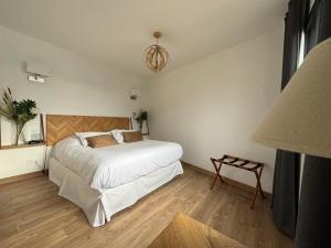a bedroom with a large white bed and a lamp at LA TOUR AUX CRABES près de la plage in Dieppe