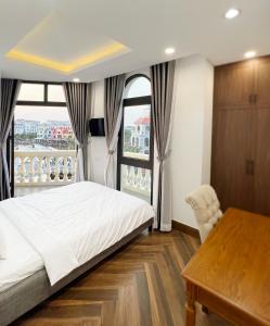 フーコックにあるLegacy Phú Quốcのベッドルーム1室(ベッド1台、デスク、窓付)
