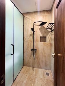 a shower with a glass door in a bathroom at Legacy Phú Quốc in Phu Quoc