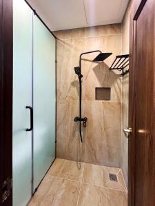 y baño con ducha y puerta de cristal. en Legacy Phú Quốc en Phu Quoc