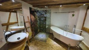 ein Bad mit einer Badewanne, einem Waschbecken und einer Dusche in der Unterkunft Bauernlodge Musauer Lechauen in Musau