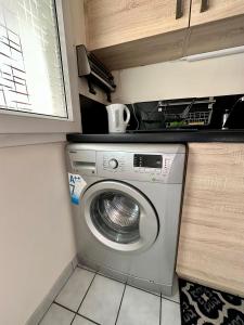 una lavatrice e asciugatrice in una piccola cucina di Appart’ calme - 48m² - proche Versailles - Paris a Élancourt