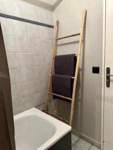 um toalheiro na casa de banho ao lado de uma banheira em Appart’ calme - 48m² - proche Versailles - Paris em Élancourt