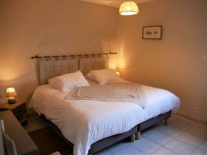 een slaapkamer met een bed met witte lakens en kussens bij Gîte Guilly, 2 pièces, 2 personnes - FR-1-590-30 in Guilly