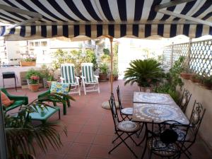 un patio con sedie, tavoli e ombrellone a righe di Casa vacanze Sciacca a Sciacca