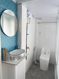 ein Badezimmer mit einem Waschbecken, einem Spiegel und einem WC in der Unterkunft Nguyên Căn Homestay OHANA - Đảo Phú Quý in Cu Lao Thu
